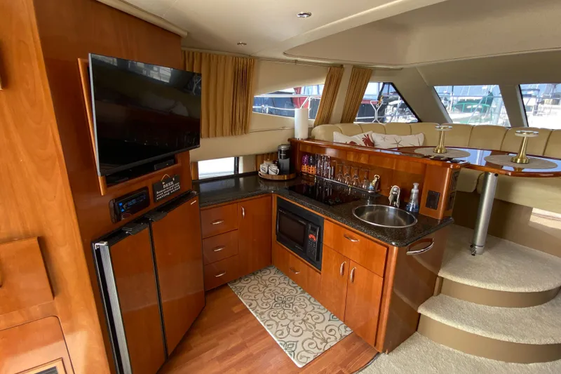 Slide: The Image of Luxurious interior of 2004 Carver 36 Super Sport yacht with kitchenette and seating area. - 7