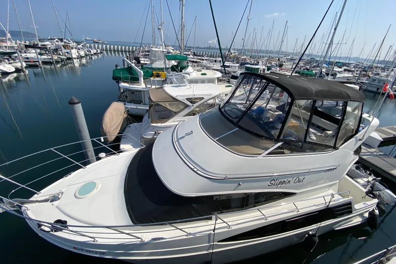 Slide: The Image of 2004 Carver 36 Super Sport yacht docked in a marina, surrounded by other boats. - 71