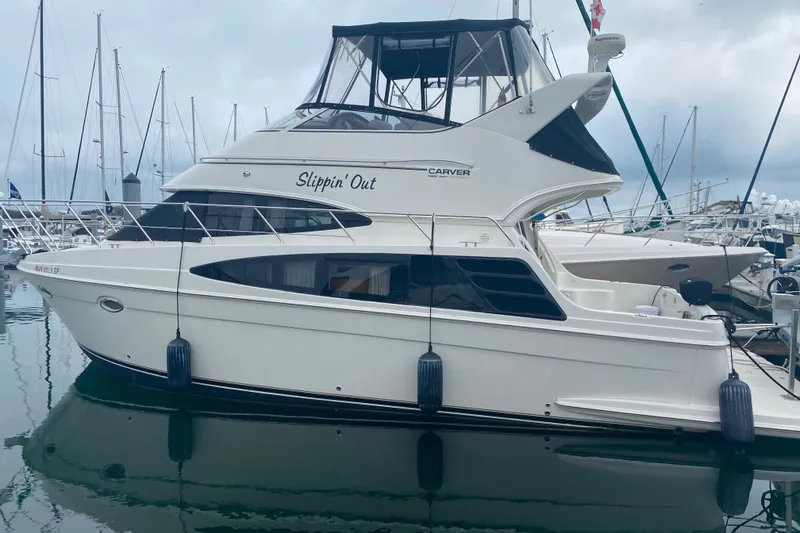 Slide: The Image of 2004 Carver 36 Super Sport yacht docked in marina, named "Slippin' Out." - 74