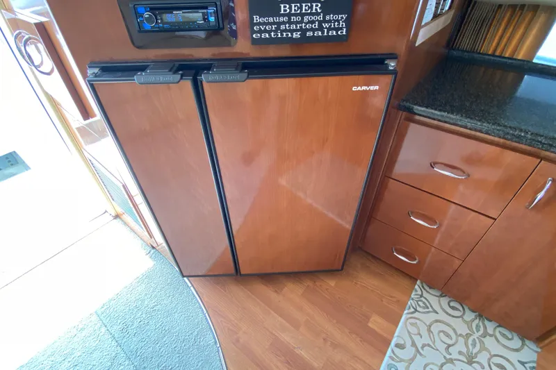 Slide: The Image of 2004 Carver 36 Super Sport interior with wood cabinetry and built-in refrigerator. - 12