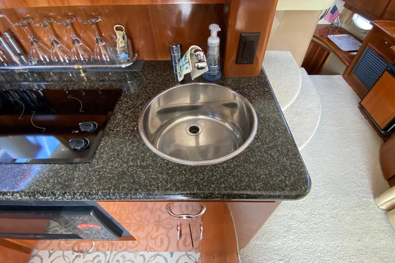 Slide: The Image of 2004 Carver 36 Super Sport yacht kitchen with sink and glassware. - 15