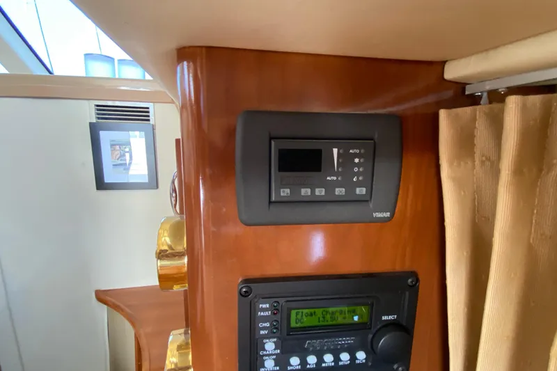 Slide: The Image of Control panel inside 2004 Carver 36 Super Sport yacht, featuring wood finish and modern electronics. - 18