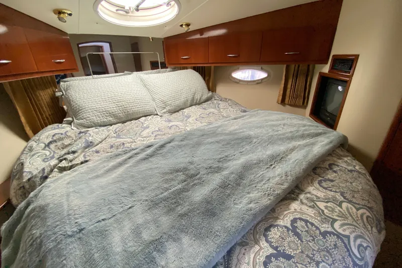 Slide: The Image of Luxurious bedroom interior of 2004 Carver 36 Super Sport yacht with cozy bedding. - 24