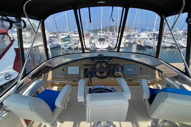 Slide: The Image of Interior view of 2004 Carver 36 Super Sport yacht helm with marina backdrop. - 34
