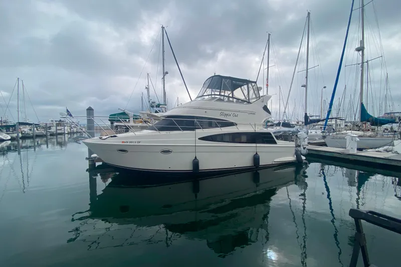 Slide: The Image of 2004 Carver 36 Super Sport yacht docked in a marina under cloudy skies. - 73