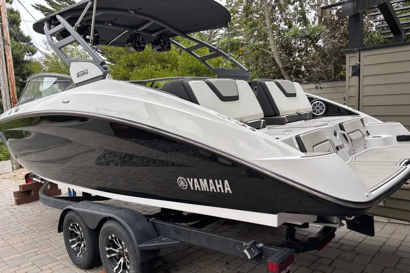 Slide: The Image of 2022 Yamaha Boats 252S on trailer, sleek design, black and white exterior. - 1