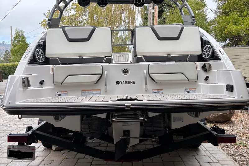 Slide: The Image of 2022 Yamaha Boats 252S rear view, showcasing seating and speakers on a trailer. - 3