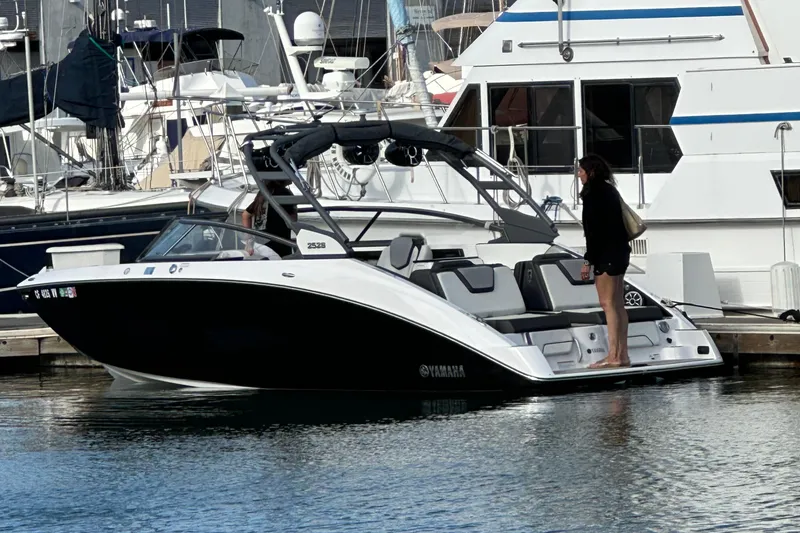 Slide: The Image of 2022 Yamaha Boats 252S docked at marina with person standing on deck. - 5