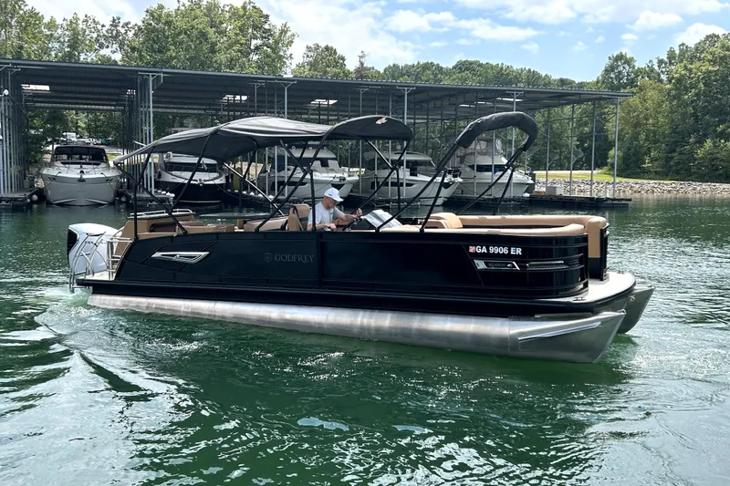 Slide: The Image of 2025 Godfrey AquaPatio Entertainment 255 CBE pontoon boat on a serene lake. - 5