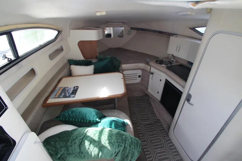 Slide: The Image of Interior of a 1996 Monterey 296 Cruiser with dining area, kitchenette, and cozy seating. - 10