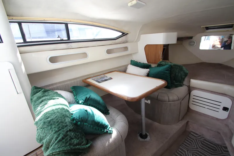 Slide: The Image of Interior of 1996 Monterey 296 Cruiser with cozy seating and green cushions. - 12