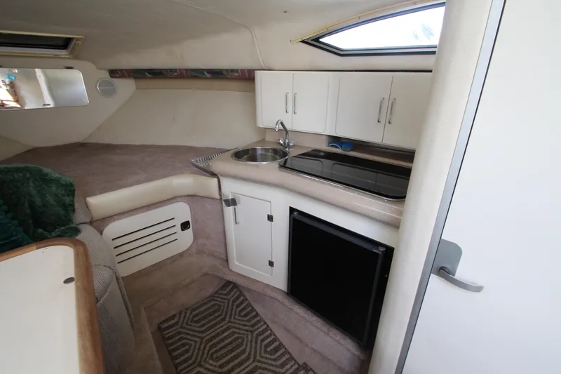 Slide: The Image of Interior of 1996 Monterey 296 Cruiser featuring compact kitchen and cozy sleeping area. - 13