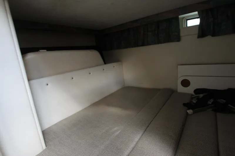 Slide: The Image of Interior cabin of 1996 Monterey 296 Cruiser with cushioned seating and small window. - 16