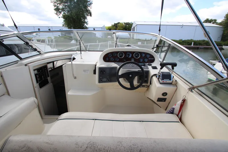Slide: The Image of 1996 Monterey 296 Cruiser helm with steering wheel and instrument panel, docked by the water. - 4