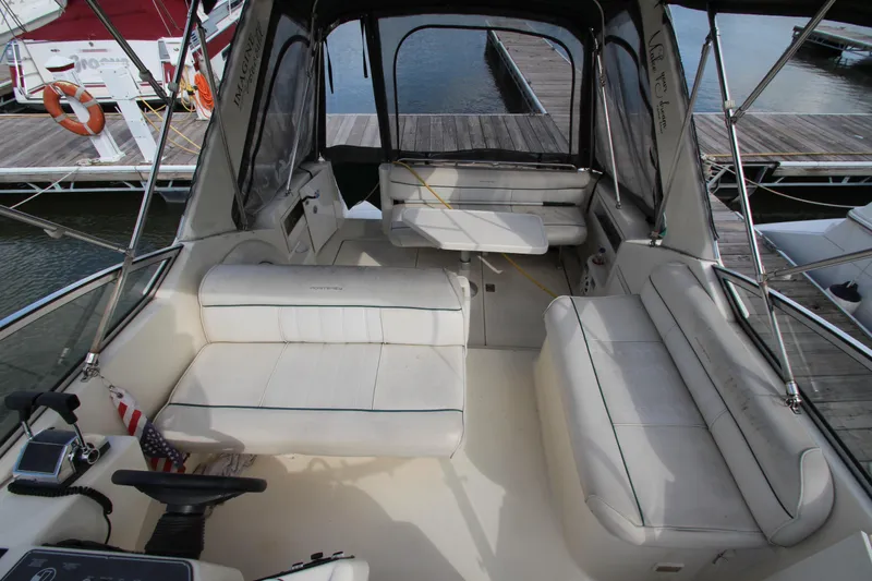 Slide: The Image of 1996 Monterey 296 Cruiser interior with white seating and dock view. - 8