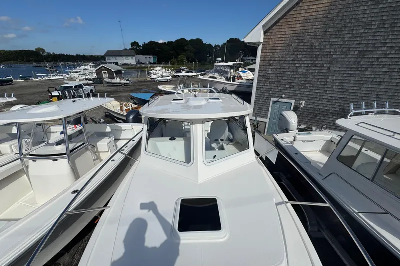 Slide: The Image of 2025 NorthCoast 255 HT boat docked among other vessels at a marina. - 12