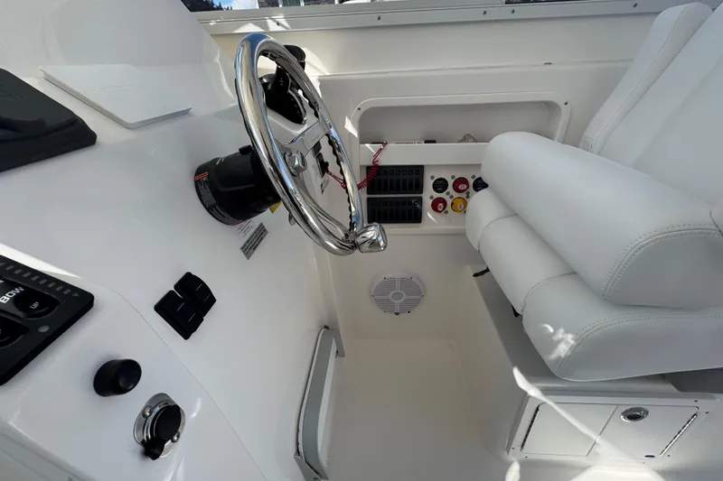 Slide: The Image of Interior of 2025 NorthCoast 255 HT boat with steering wheel and white seating. - 21