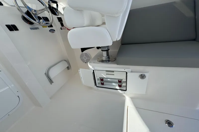 Slide: The Image of Interior of 2025 NorthCoast 255 HT boat with white seating and storage compartments. - 22
