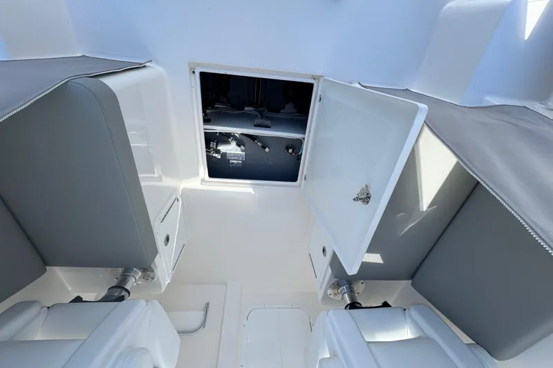 Slide: The Image of 2025 NorthCoast 255 HT boat interior with open storage compartment and cushioned seating. - 24