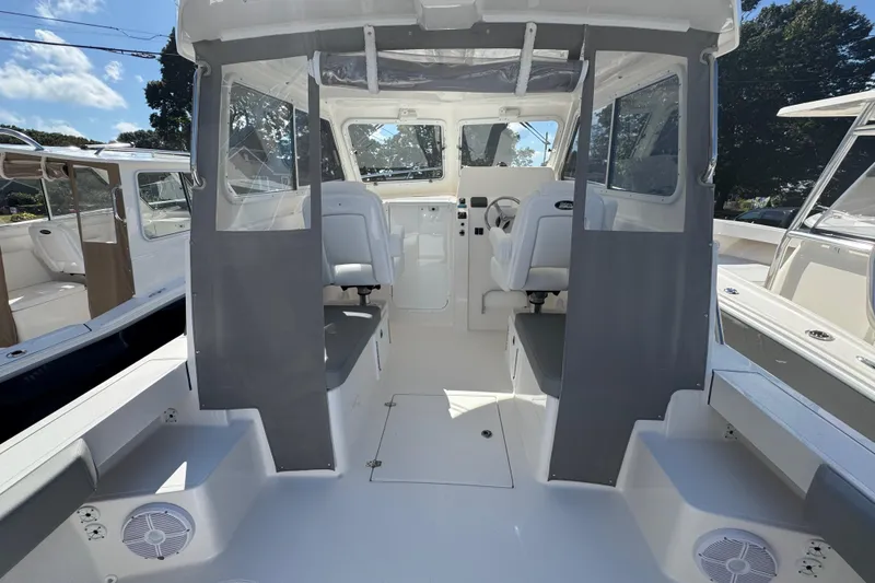 Slide: The Image of 2025 NorthCoast 255 HT boat interior with helm, seating, and clear canopy. - 3