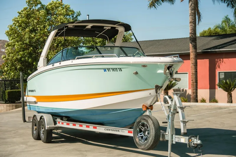 Slide: The Image of 2023 Chaparral 287 SSX boat on trailer, parked outdoors with palm trees. - 3