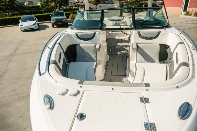 Slide: The Image of 2023 Chaparral 287 SSX boat with luxurious white interior, parked outdoors. - 30