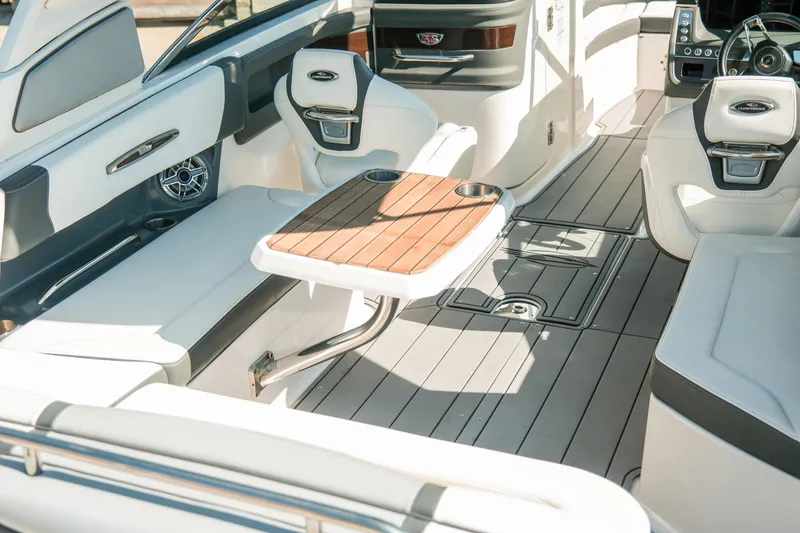 Slide: The Image of 2023 Chaparral 287 SSX boat interior with elegant seating and wooden table. - 7