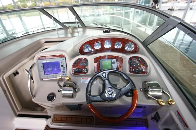 Slide: The Image of 2007 Sea Ray 320 Sundancer dashboard with electronic display and wood paneling. - 24