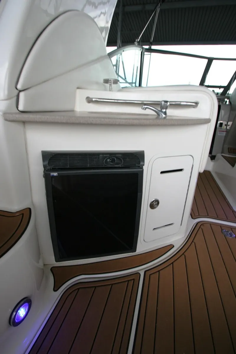Slide: The Image of 2007 Sea Ray 320 Sundancer interior with helm, seating, and kitchenette. - 37