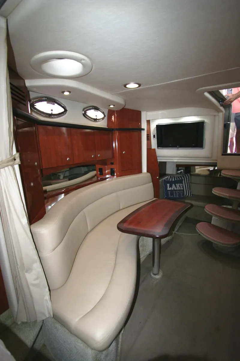 Slide: The Image of 2007 Sea Ray 320 Sundancer interior with leather seating, wooden cabinetry, and a mounted TV. - 8