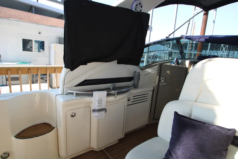 Slide: The Image of 2006 Sea Ray 400 Sundancer yacht with white seating and navy accents in a marina. - 54
