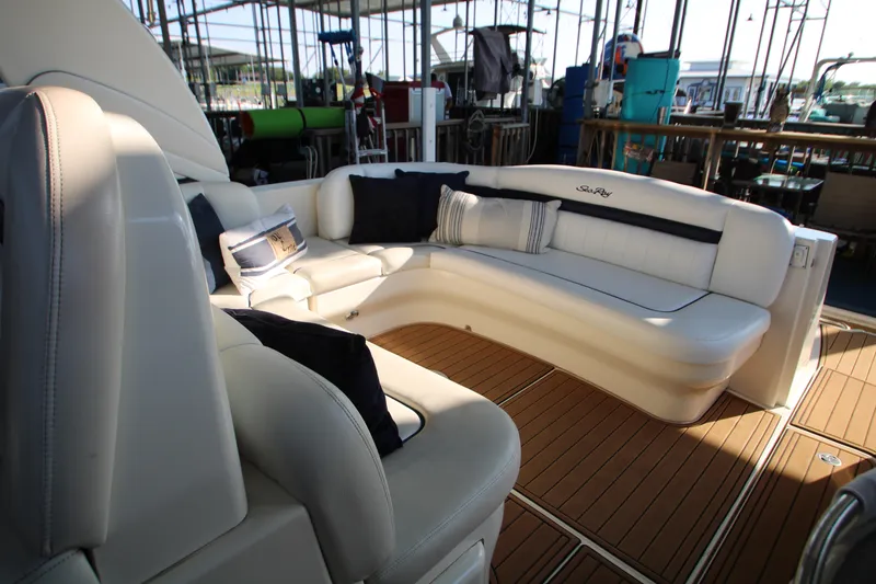 Slide: The Image of 2006 Sea Ray 400 Sundancer cockpit with helm, white seating, and dashboard controls. - 58