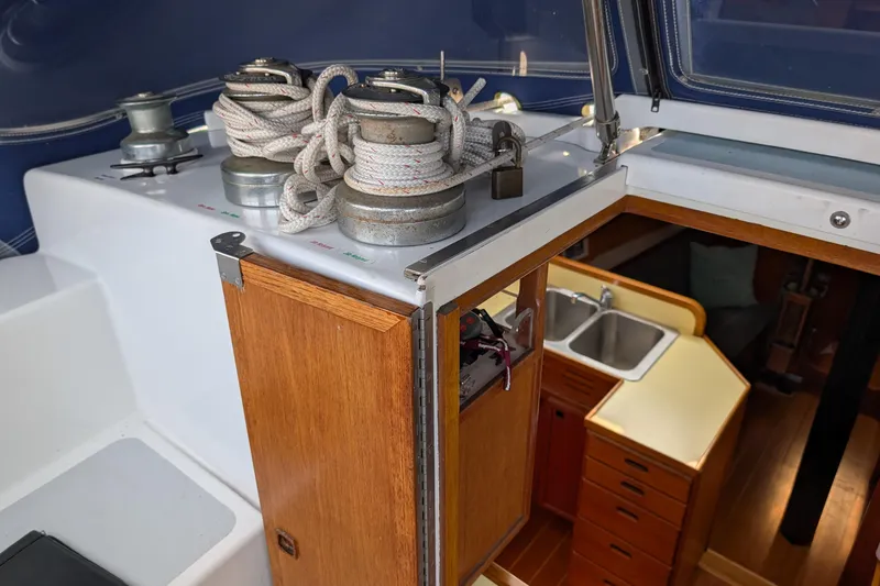 Slide: The Image of 1987 Cascade Center Cockpit sailboat interior with winches, ropes, and wooden cabinetry. - 13