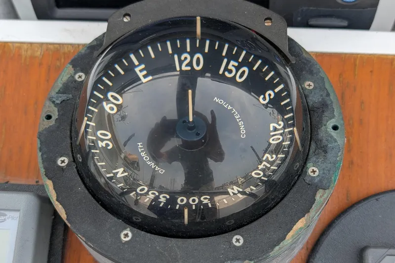 Slide: The Image of Vintage 1987 Cascade Center Cockpit compass with directional markings on a wooden surface. - 22