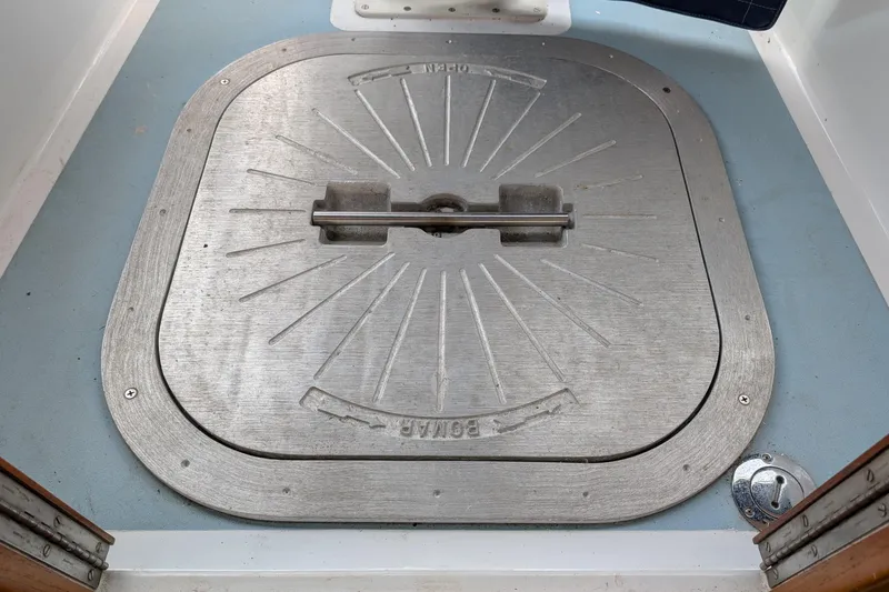 Slide: The Image of Metal hatch on 1987 Cascade Center Cockpit boat deck, featuring a secure handle. - 24