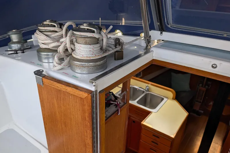 Slide: The Image of 1987 Cascade Center Cockpit sailboat interior with winches, ropes, and wooden cabinetry. - 28