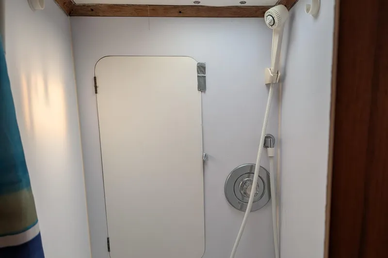 Slide: The Image of Shower area in 1987 Cascade Center Cockpit boat with white walls and wooden trim. - 33