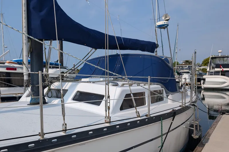 Slide: The Image of 1987 Cascade Center Cockpit sailboat docked in marina, featuring blue canvas cover. - 4