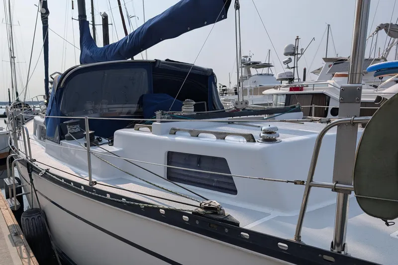 Slide: The Image of 1987 Cascade Center Cockpit sailboat docked at marina, featuring sleek design and blue canopy. - 5