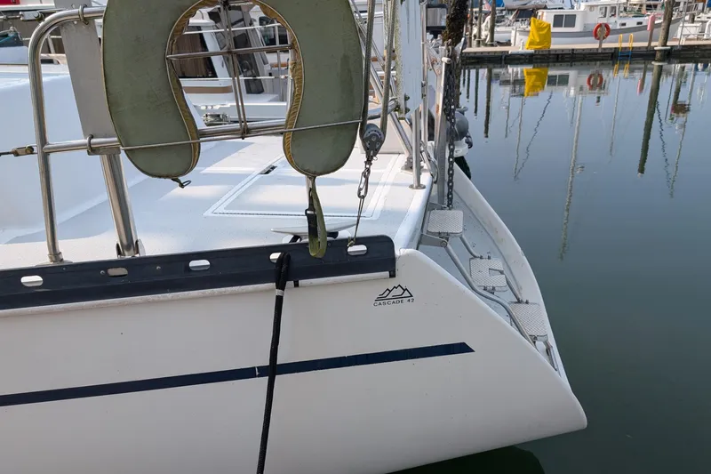 Slide: The Image of 1987 Cascade Center Cockpit sailboat docked at marina, featuring lifebuoy and clean deck. - 6