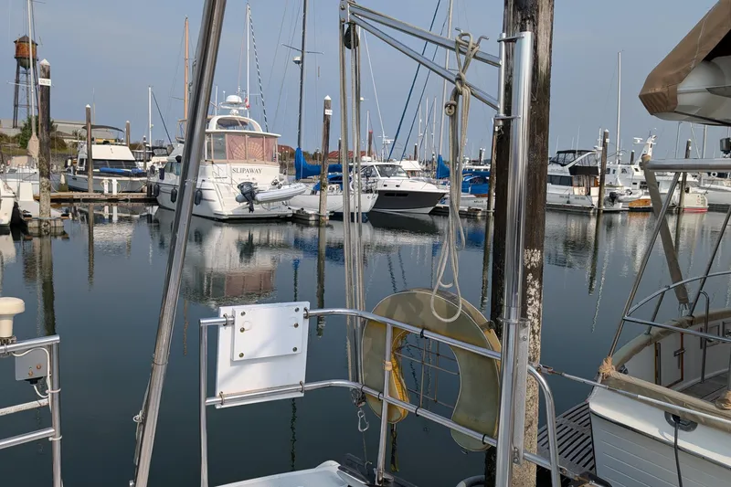Slide: The Image of Marina with various boats, including a 1987 Cascade Center Cockpit, docked in calm waters. - 7