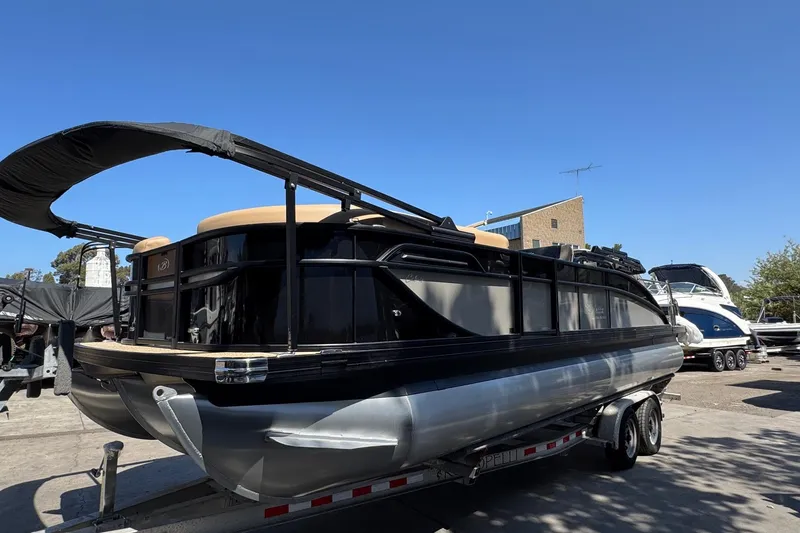 Slide: The Image of 2026 Barletta Cabrio 24UE pontoon boat with Mercury engine on trailer, outdoor setting. - 10