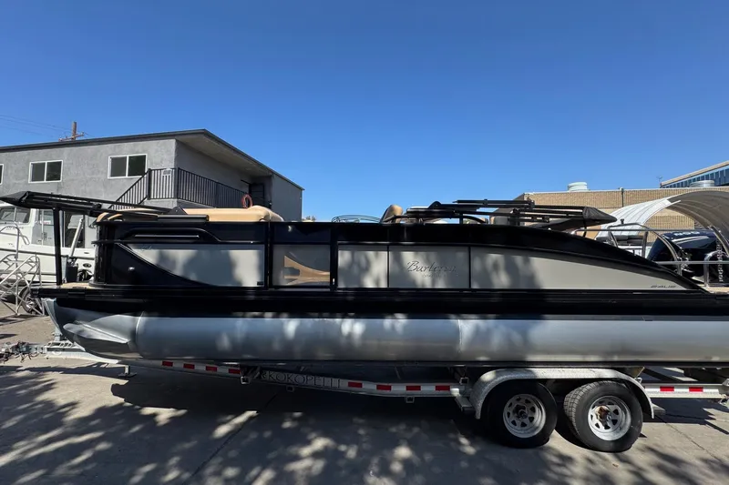 Slide: The Image of 2026 Barletta Cabrio 24UE with Mercury outboard engine in a boatyard setting. - 11