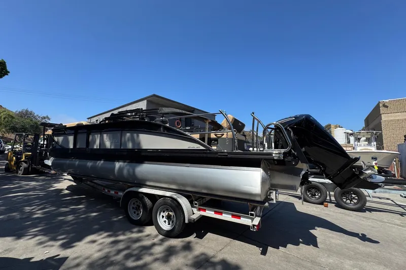 Slide: The Image of 2026 Barletta Cabrio 24UE pontoon boat with Mercury outboard motor, parked outdoors. - 12