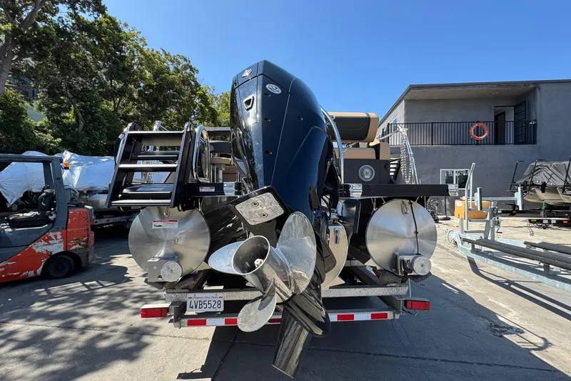 Slide: The Image of 2026 Barletta Cabrio 24UE pontoon boat on trailer, featuring Mercury outboard motor. - 13