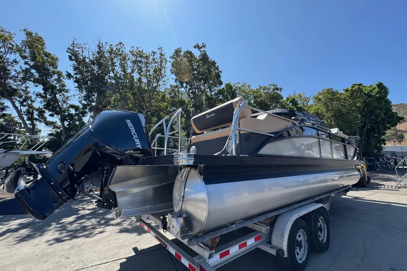 Slide: The Image of 2026 Barletta Cabrio 24UE pontoon boat with spacious seating and canopy, docked outdoors. - 15