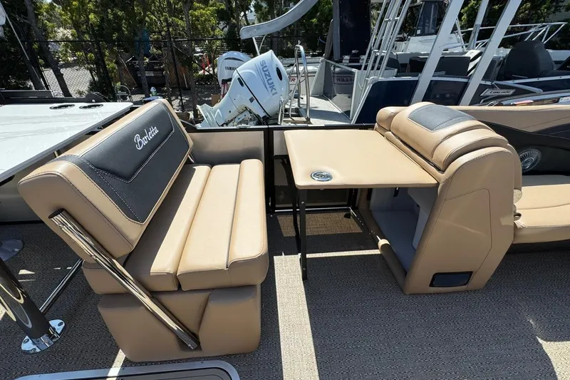 Slide: The Image of Barletta Cabrio 24UE 2026 boat interior with built-in cooler and tan seating. - 39