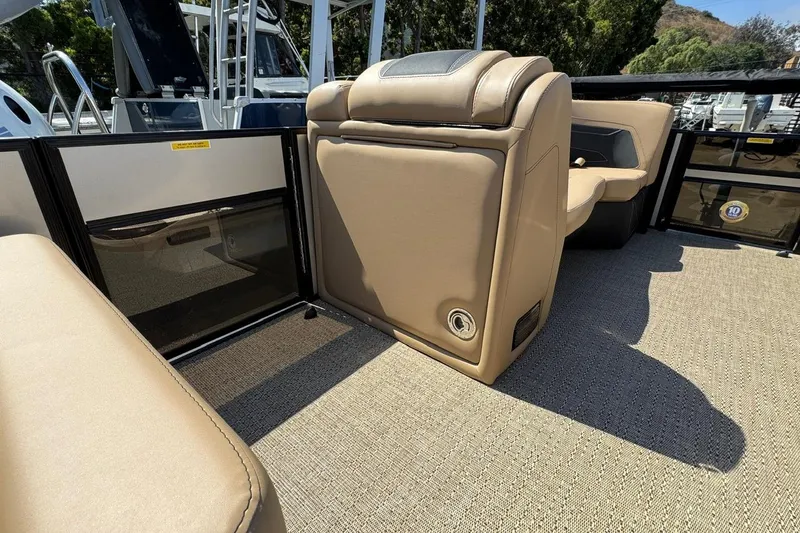 Slide: The Image of Barletta Cabrio 24UE 2026 boat interior storage compartment with beige and black seating. - 41