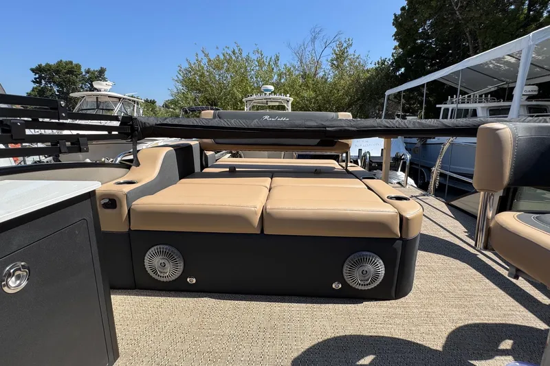 Slide: The Image of 2026 Barletta Cabrio 24UE boat seat with storage compartment, featuring beige and black upholstery. - 56