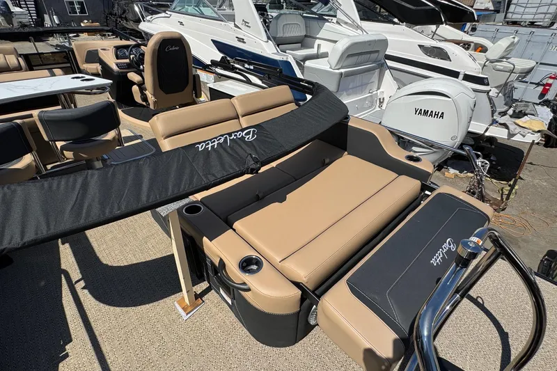 Slide: The Image of 2026 Barletta Cabrio 24UE boat interior with open storage compartment and beige seating. - 60